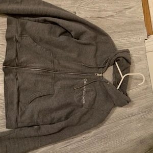 Calvin Klein - Grå Hoodie med en dragkedja från Calvin Klein.