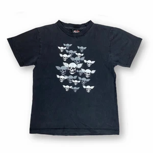 T-Shirt  - Cool baby tee från Akama T-Shirt. Storlek 140 ålder 9-10. Skulle passa XS. 100% bomull. Tight runt bysten för modellen som använder 75B. Modellen använder vanligtvis storlek S / M och är 169cm för referens.  Axel till axel 38cm, ärmlängd 16cm, Bystbredd 42cm och Shirtlängd 53cm. Spårbar frakt på 66kr är inräknad i priset. 