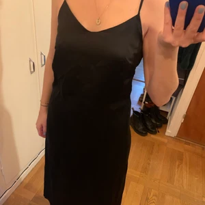 Klänning NAKD svart stl S/36 - Svart klänning i mjukt tunt material. Storlek S/35 men vid i storlek. Slits nertill. Reglerbara axelband