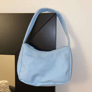 Väska GinaTricot - Säljer en oanvänd juliebag i ljusblå. Frakt tillkommer om den behövs skickas. Kan HÄMTAS i Trollhättan. 