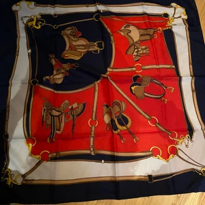 Sjal med sadlar - Jättefin marinblå och röd sjal med sadlar på! Passar perfekt till att knyta runt håret!