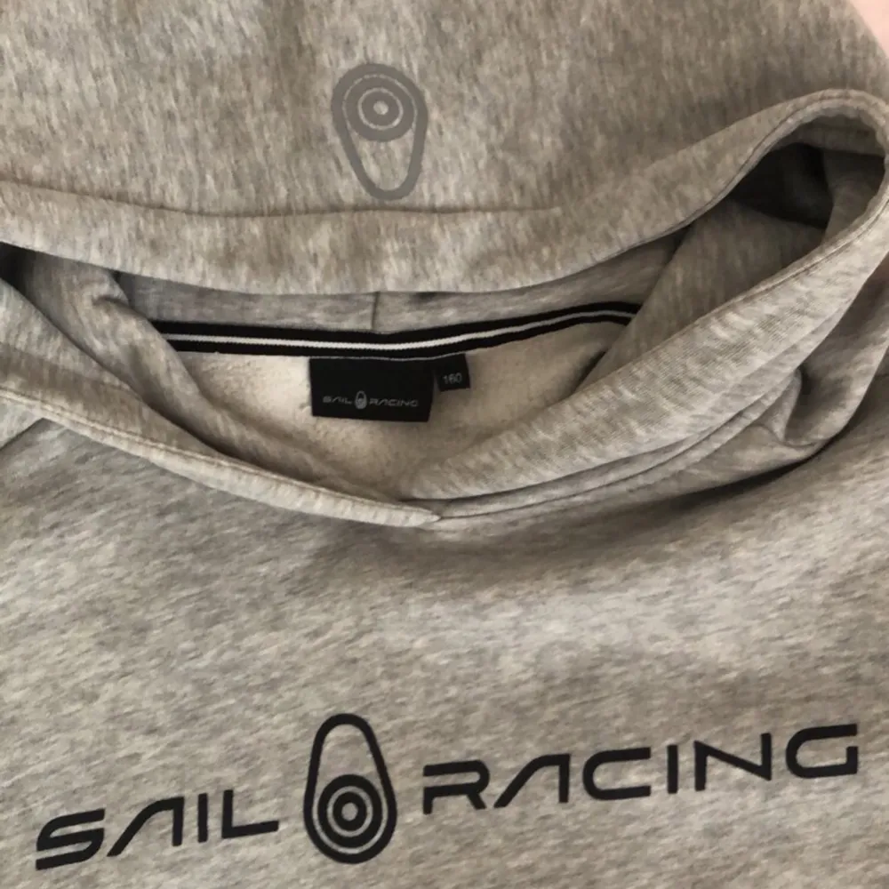 En sail racing hoodie på färgen grå, har logo på luvan och är perfekt för hösten och sommar kvällar. Har använt den två gånger, den är väldigt fin och passar med alla typer av byxor💕. Tröjor & Koftor.