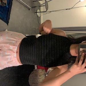 En svart kort polo - Den är ganska tight vid huvudet, och sitter bra på kroppen, haft den ett tag oxh haft på mig den ett bra antal gånger. Den har en kort polo och guld i ränder som detalj.