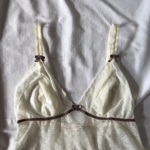 Vitt nattlinne med lila detaljer  - Gulligt vitt nattlinne med lila rosetter och kant. Helt gjord av spets men skulle vara ursnyggt som layeringplagg nu till hösten! Uppskattas passa storlek s (36) bäst! Köpare står för 24kr frakt. Gott defetfritt skick. Bud: 400kr. Fortgår tills plagget markeras sålt så buda på. Du vinner budgivningen om ingen budar mer än dig på 24 timmar