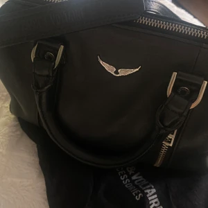 Zadig väska  - Säljer nu min jätte snygga Zadig sunny bag i mellan storleken. Den är i bra skick men har tappat lite färg på spännena och blivit lite sliten på hörnen (se sista bilden) men verkligen inget anmärkningsvärt. Den passar verkligen till allt! Köptes för några år sen för cr 3500kr. Kan mötas eller så står köparen för frakten.💓 köp direkt för 2500kr.