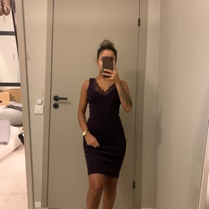 Klänning  - Klänning i mörklila färg med guldig dragkedja, i bra skick. 