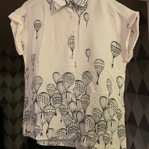 Blus Zara i silkesmix M - En rak blus med tryck från Zara. Silke 40%, viskos 60%. Skön till huden och lätt att stryka. Passar S/M. Längden 65 cm