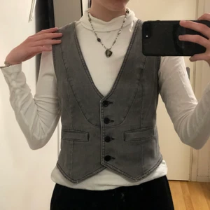 Grå jeansväst - ascool grå väst med coola detaljer. spänne i ryggen. storlek 42 men jag på bilden bär vanligtvist 36/38