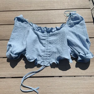 Blå topp strl XS  - En blå söt topp i storlek XS. Aldrig använd. Det finns en drajtkedja i sidan. Ni får buda, start pris 100kr Buda i kommentarerna