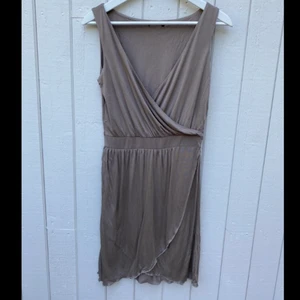 Beige omlottklänning - Beige omlottklänning i tunt material med snygg ringning. 