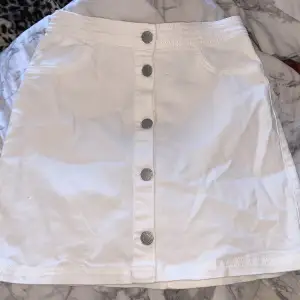 En vit kjol med knappar där fram inte använt 