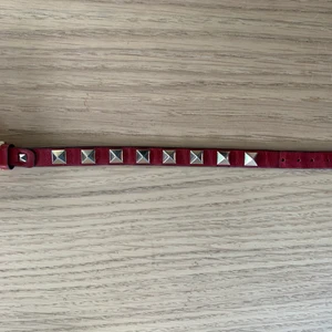 Valentino - Säljer mitt röda Valentino rockstud armband. Armbandet är några år gammalt och använt (se bilder). Har blivit limmat en gång och de syns lite, men funkar självklart som vanligt (se bild 3). 100% äkta köpt i Köpenhamn,  box medföljer om man vill. Pris + frakt. 