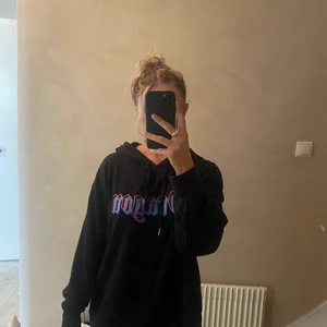 Svart lång hoodie med tryck - Svart lång hoodie med blå/rött tryck både bak och fram, storlek M, går över rumpan (jag är 158cm)