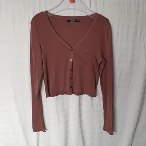 Brun topp/cardigan - Brun topp med knappar från BikBok 🤎 Kan både has som topp eller cardigan. Toppen är väldigt stretchig och mjuk. M, men passar även S. Använd 1 gång. 😊