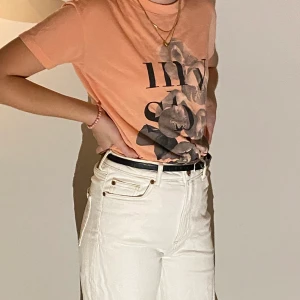 T-shirt XS - En orange t-shirt med tryck, storlek xs.