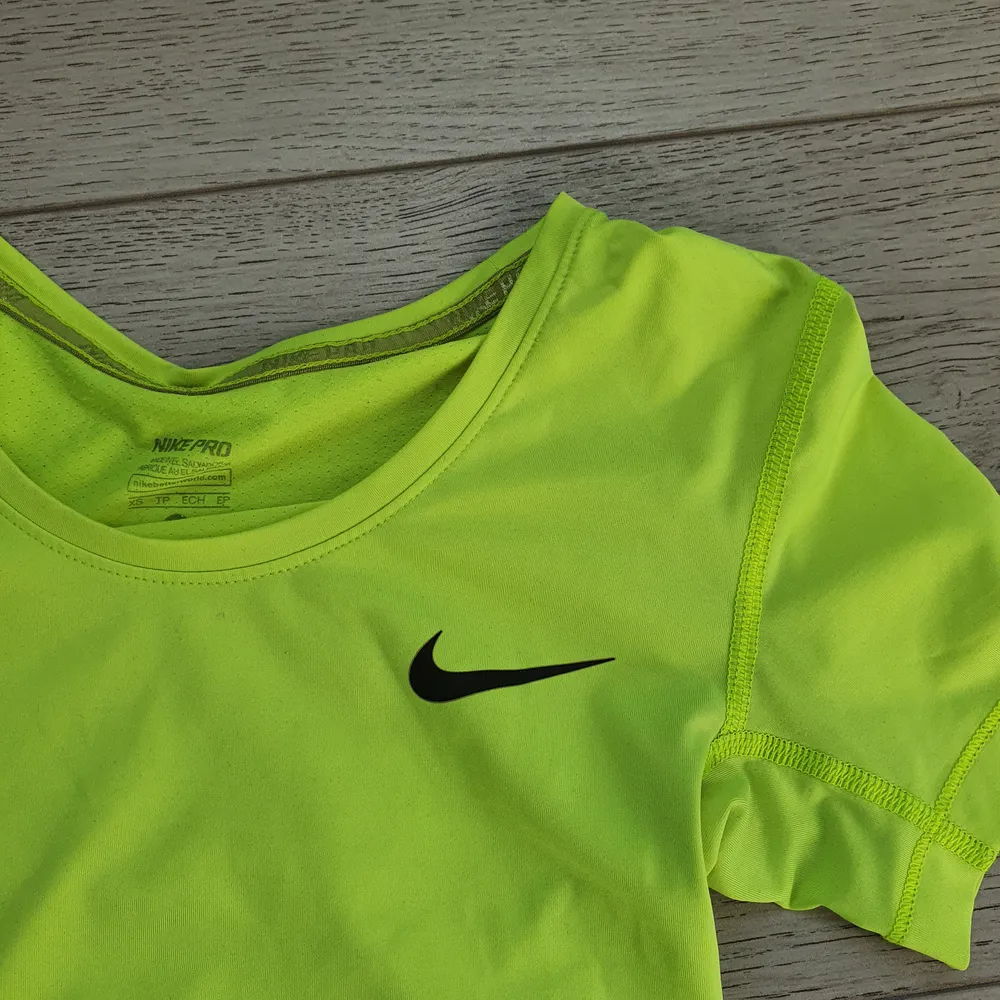 Säljer denna grön/gula nike T-shirten! Superskönt stretchigt material som andas bra. Tröjan är tajt och lite längre, på första bilden är den uppvikt💕  knappt använd.                                                  70 kr + frakt 45 kr eller 66 kr spårbart!  (köparen står för frakten), betalning via swish. T-shirts.