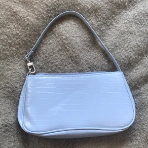 Blå sholder bag - Säljer denna snygga ljusblåa väskan. Perfekt för att spicea up din sommar outfit!! Bandet sitter perfekt runt armen med ett lite kortare band. Kom privat för fler bilder, intresse eller bestämt köp🤍