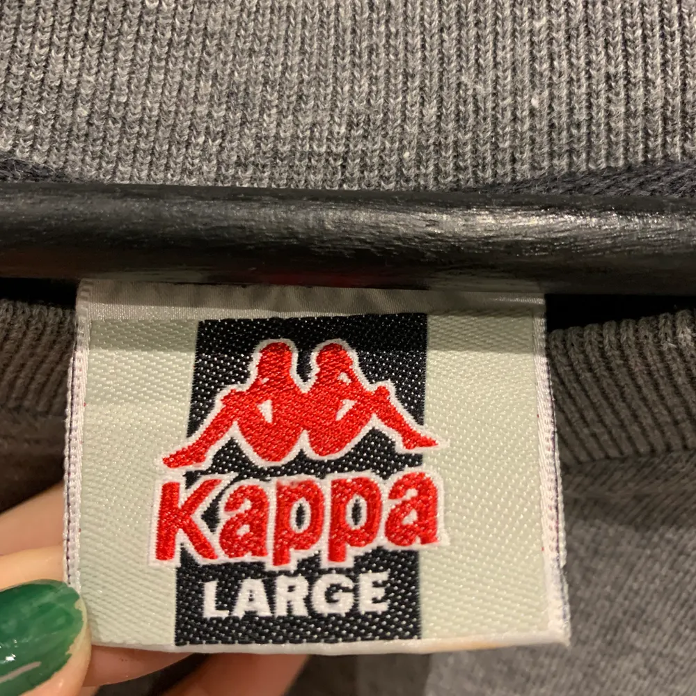 Oversized grå sweatshirt från Kappa med orange, svart och vita detaljer på sidan. Aldrig använt den själv men köpt på Humana i Göteborg. Storlek L men passar även andra storlekar beroende på hur man vill att den ska sitta. Pris kan disskuteras, 66kr frakt tillkommer:). Hoodies.