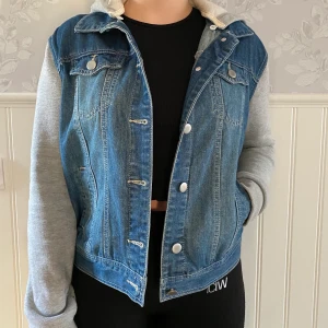 Jeansjacka storlek M - Jeansjacka med gråa ärmar i Hoodie-material med luva från Forever 21. Bra skick. Storlek M, men passar mig som vanligtvis brukar ha storlek S💙