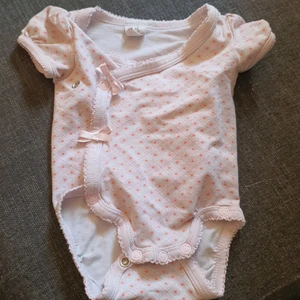 Body - Säljer en ljuslila body med blommor och rosett detaljer, använd fåtal gånger så den är i mycket gott skick.