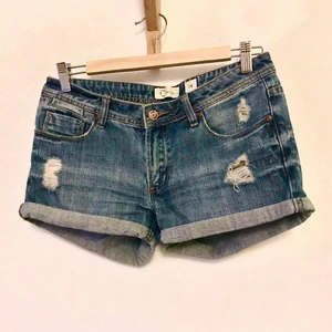 Jeansshorts, 30 - Snygga shorts! En blå Denim som inte helt framkommer på bild (kan skicka fler bilder i dagsljus). Mäter ca 38 cm i midjan. Så snygg tvätt med lite slitningar i. Kan mötas i Stockholm eller skicka mot fraktkostnad! ✨🌸✨