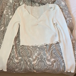 Strl S men kan funka som M - En vit fin kroppad långärmad topp. Frakt ingår i priset