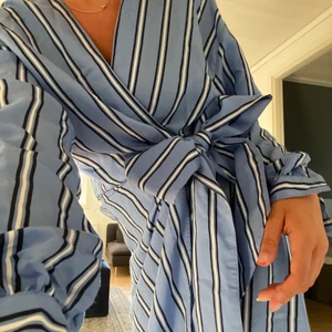 Randig klänning  - En blå/svart/vit randig omlott klänning från H&M 