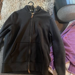 Hoodie med dragkedja, burberry - En hoodie med dragkedja i märket burberry. Den är trasig i armbågarna så därför blir det ett lägre pris men det är fortfarade burberry. Nypris ca 3000kr.