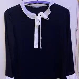 Black bell sleeve blouse, with a self tie neck.