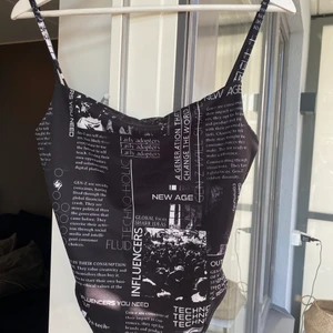 Body med text - Ett jättefint body-linne med text och mönster på från Collusion. Använd 1 gång men den sitter inte riktigt bra på mig och därför säljer jag den. Köparen står för frakt. 