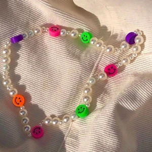 Vitt pärlhalsband med smileys  - Vitt pärlhalsband med färgglada smileys, kostar 45kr+13kr frakt.                                                                 Bilderna är från min instagram design.by.d_ så kolla gärna in💕