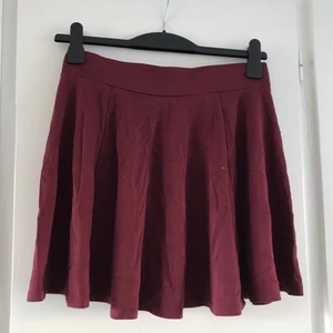 Skater-kjol - En vinröd skater-kjol med hög midja från H&M ❤️ Kort och flowy med tight midja! Säljes billigt pga den har en liiiiten färgfläck på sidan (se bild) men är i fint skick, hel och fin annars 💕🌙 Snygg till vans och en tjocktröja 😍 Passa på för lågt pris!! 