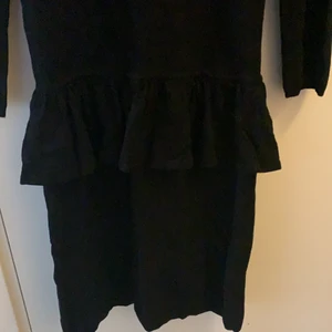 Svart klänning - Svart klänning i tunnt bomull med en volang vid höften.