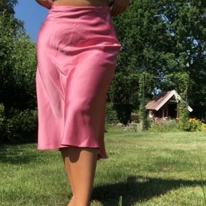 Rosa satinkjol - Rosa satinkjol i från Zara, köpt på plick. Litet hål där dragkedjan börjar som säkert lätt går att laga. En del slitningar på kjolen. 
