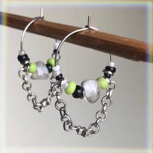 Örhängen🌿 - Örhängen i rostfritt stål med seed beads i vitt, svart och grönt. I mitten är det en vit glaspärla och på kedjan sitter det en stjärna⭐️💫De är ungefär 2 cm på bredden och 3 cm på längden. Säljer för 50kr + 12kr i frakt!!