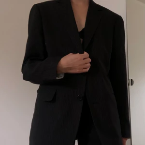 Svart kavaj - Svart kritstrecksrandig kavaj köpt second hand, färgen stämmer bäst med första bilden och varken märke eller stl finns men jag skulle säga att den är ca herrstorlek M! 🤓