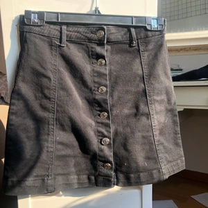 Svart jeanskjol från GinaTricot - Svart jeanskjol med knappar, storlek 34 från Gina.