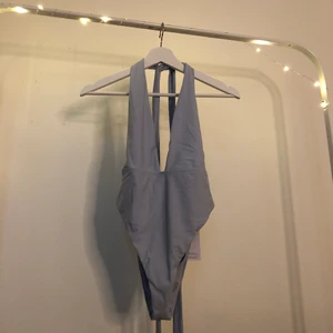 Baddräkt  - En blå baddräkt som man knyter i naken från Tobi i stl m den är aldrig andvänd, lappen sitter även kvar på den.