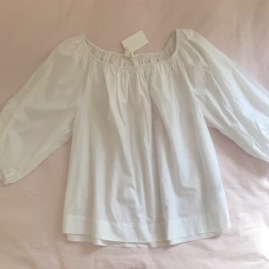 Vit ofshoulder blus - Vitt of-shoulder blus från HM. Aldrig använd, prislapp kvar! Går att både ha ofshoulder eller med axlarna uppdragna.💞💞