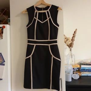 Svart klänning i storlek 10 - Svart, kort klänning med beigea mönster, i storlek 10. Den är sparsamt använd 😊