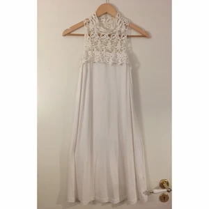 Klänning vit - Säljer en vit klänning med fint mönster upptill, perfekt till skolavslutning/student.👗 Plagget är tunt, luftigt och stretchigt samt har knappar vid nacken där bak (se bild). Rekommenderar något under klänningen då den är aningen genomskinlig. Den slutar ovanför knäna på mig (163cm) och är strl XS men passar även en S eller mindre M. Plagget har använts en gång. Meddela mig vid fler frågor!😄