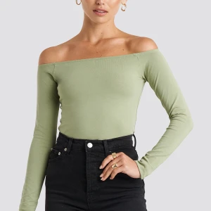 Grön topp - Säljer denna gröna off shoulder topp från NA-KD i storlek XS. I nyskick. Egna bilder kan skickas.