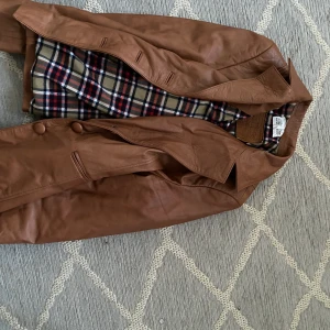 Brun skinnjacka - Brun skinnjacka i L, något kroppad i armarna