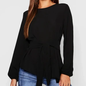 Topp med knytband  - Säljer denna fina topp som använts endast 3 gånger! Den framhäver former fint med hjälp av knytbander som man kan knyta hur löst eller hårt man vill. Passar till allt! Storlek 36