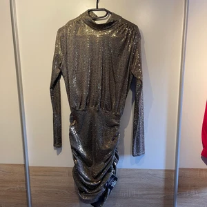 Glittrig klänning  - En fantastisk klänning som hör hemma på dansgolvet! Den är helt ny (etikett är på fortfarande) och är köpt på Nelly.com. Ord.pris 599kr