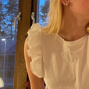 Vit topp - Super söt vit topp med volang ärmar, jätte fin att ha på sommaren. Säljer pga att jag har en till likadan! (pris och frakt kan diskuteras) 