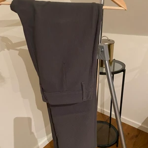 Ribbade kostymbyxor  - Ribbade kostymbyxor i rak design. Snygg grå färg men långa på mig som är 162 därav jag säljer. 