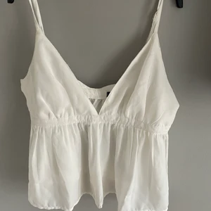 Linne ifrån Bikbok - Superfint vitt linne ifrån bikbok, fin v-ringning, justerbara band och i toppen skick då den endast e använd en gång. Säljer då den ej kommer till användning 💕