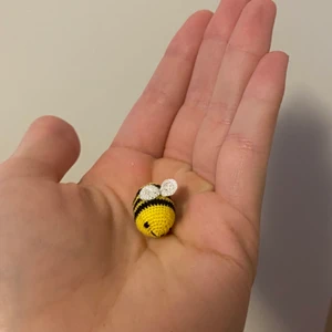 Virkad humla  - Handgjord virkad mini humla. Gul färg. Material; bomullstråd, polyester vadd, platsögon. Mått: ca 1,2 cm • 2 cm. Frakt inom Sverige ingår i priset. Betalas med Swish. 