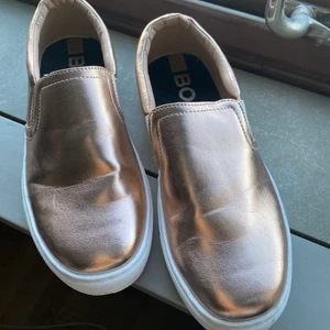 HugoBoss slip-ons strl 36 - Guldiga Hugo Boss skor i storlek 36. Knappt använda, så inga defekter. Säljer pga att jag inte använder dem. 